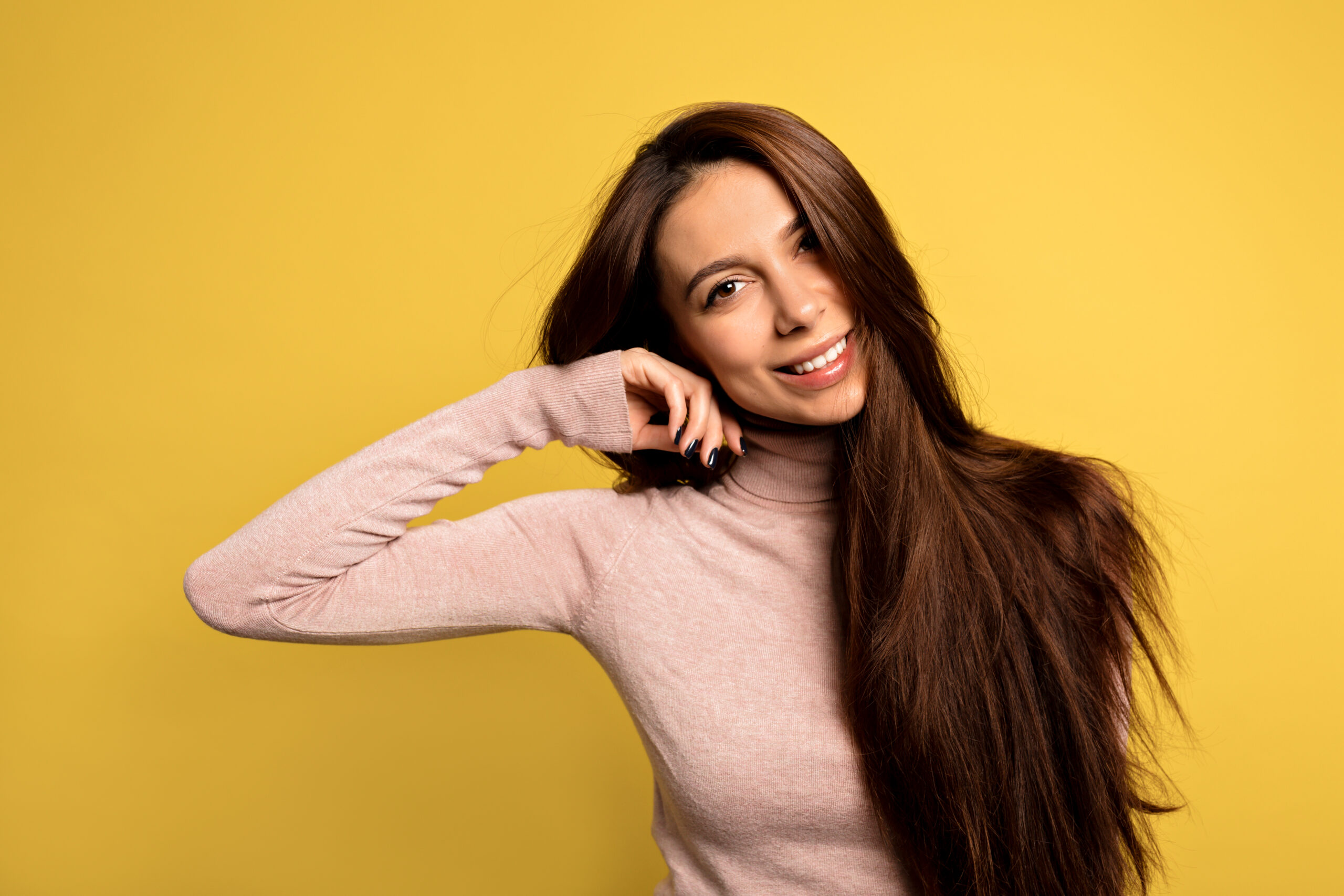 elegant-european-girl-with-beautiful-brown-eyes-touching-chin-with-fingers-gently-smilling-close-up-portrait-trendy-young-woman-posing-yellow-room hair growth