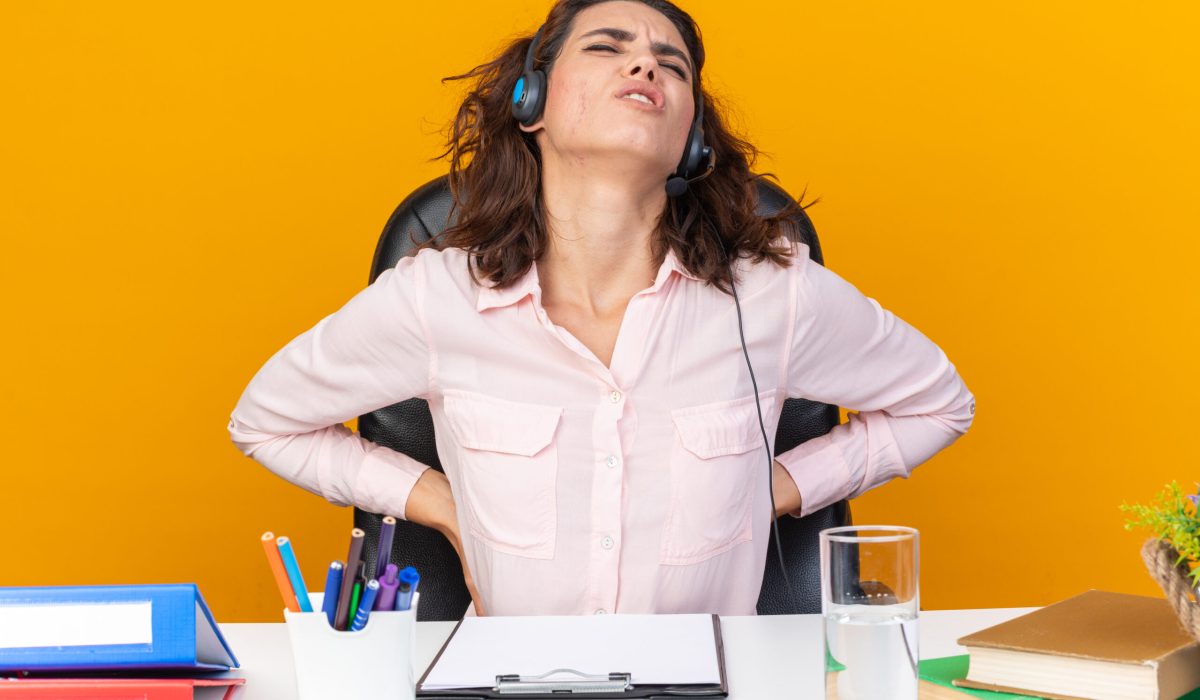 aching-pretty-caucasian-female-call-center-operator-headphones-sitting-desk-with-office-tools-holding-her-back-isolated-orange-wall aching pretty caucasian female call center operator on headphones sitting at desk with office tools holding her back isolated on orange background SSUCv3H4sIAAAAAAAACpyRy47DIAxF9yPNP0SsGymv0mR+pZqFA06DSqEC0tGo6r8Pj1Cxnh0+tq99zfPzo6rIDFYw8lU9Q+RjIeVmnQEntPK4OezcoOJoSvIwPW1KgFw4bQTIEs7g2Krghh6qTcqAXzFJrAO3WbRh+o4YOLx4jQTfEmnFc4qrnIhJ3+FThBwKZrc5soyS+L860+M7u4ELKvYbFy6MGJQIycg5lZLrj0NzK63BxoUuXD00AxkK+kLpbgQT6lK0abfGs+c2pjflTFjhvTmRWt9hluHEi9fEzFew1pfzzItBzH+yvhVzlHbRwK5KuP+JELZ9R/vjMNKpmSbaneiwF6TfW4XXietkIR+zq+CldRE2IGO/tDg2x3qeGK2HkWE9w9TUp6Vrm44zpMfJH/71BwAA//8DAPrmSiOYAgAA