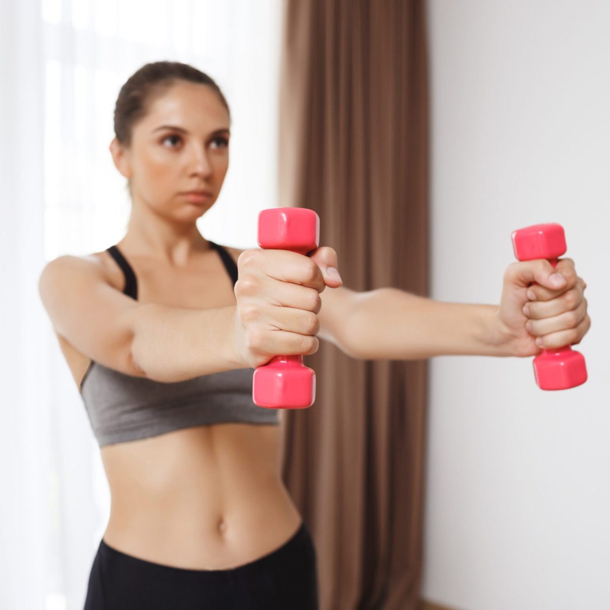 Beautiful fitness girl make sport execises Beautiful fitness girl make sport execises. Focus on hands holding dumbells.