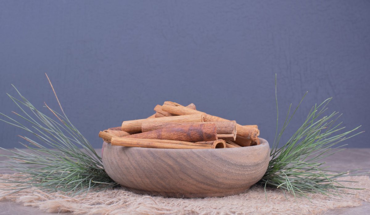 Cinnamon sticks in a wooden cup with oak tree branch around hormonal balance